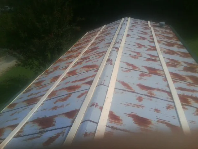 Rusted metal roof panels with new wood purlins before replacement — Storm Damage Roof Repair in Taft by Roofing Brothers
