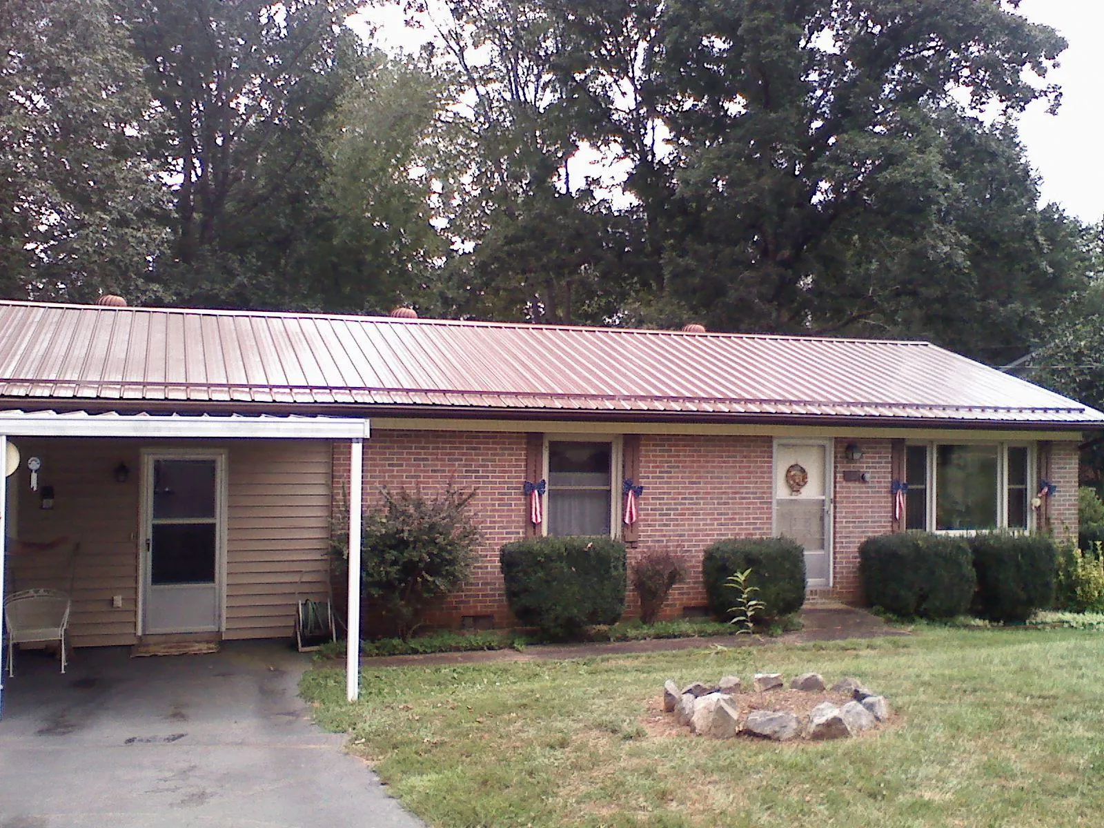 Bronze metal roof and carport on a brick ranch home — Roof Repair work by our crew in Taft