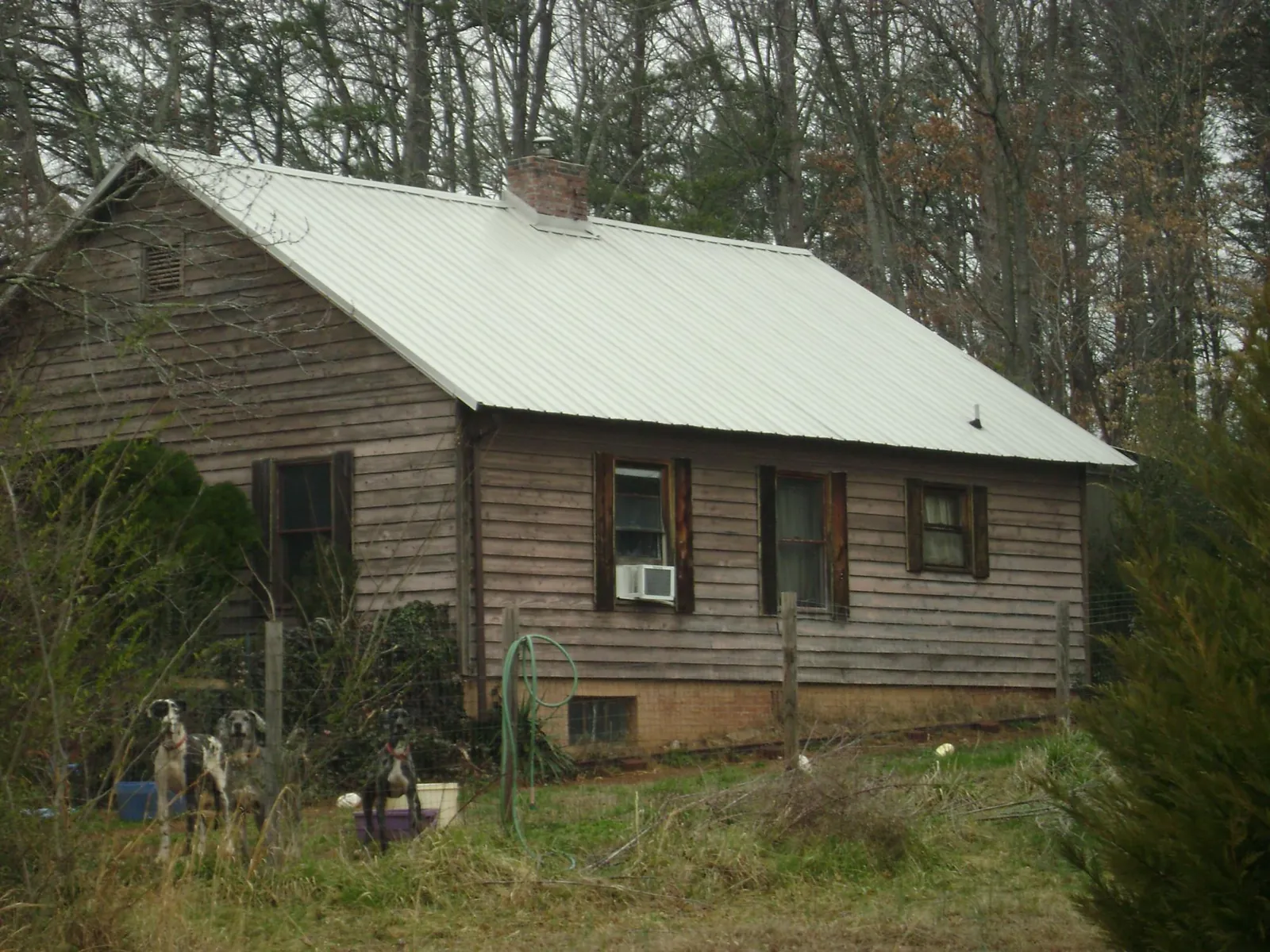 White metal roof on an old wood sided farmhouse, from a Metal Roof Installation job in Taft
